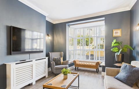 Large open-plan living area with comfortable seating, modern decor, and a flat-screen Smart TV, perfect for family movie nights.