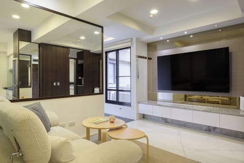 nice living room with wifi, A/C, big TV, cozy couch, and wearing mirror.