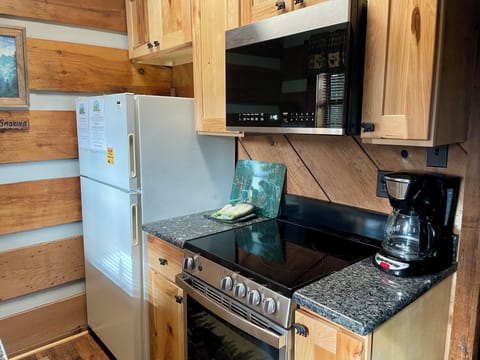 Kitchen with full-sized refrigerator, stove, oven, microwave oven and standard coffee maker