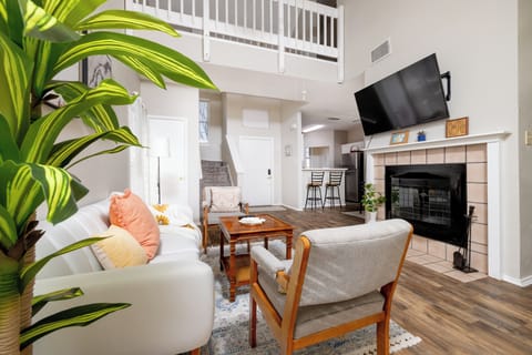 Spacious living room with fire place and large smart tv.