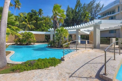 Dive into paradise! Our sparkling pool is surrounded by lush tropical landscaping, offering a refreshing escape and a perfect spot for sunbathing and relaxation.