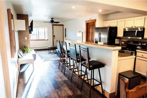 The kitchen has a large island with 4 bar stools.