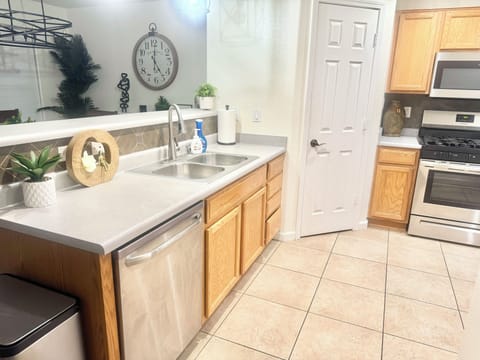 Dishwasher, laundy soap and other cleaning supplies are located under the sink.