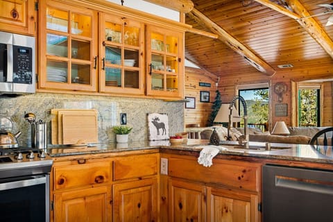 The combination of sleek granite countertops, chic backsplash, and the warmth of pine cabinets creates a welcoming environment that inspires culinary creativity.