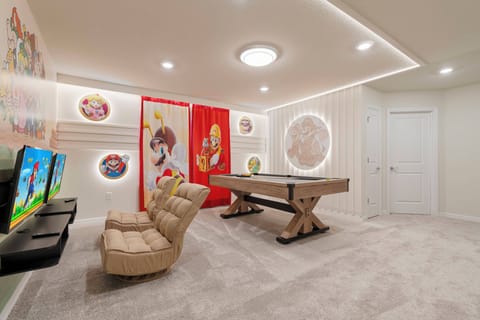 Discover a lively game room designed for fun and relaxation, complete with comfy beige seating and a stylish pool table under soft modern lighting. Colorful wall art and playful accents ensure an inviting atmosphere for everyone.