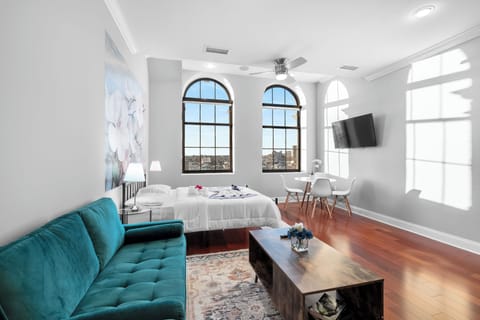 Spacious Northern Liberties studio with queen bed, full kitchen, modern bathroom, and arched windows throughout.
