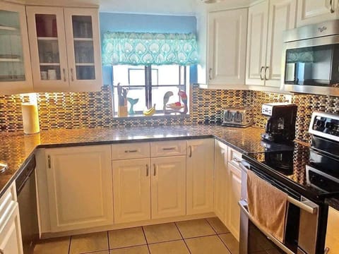 Bright & Beautiful Kitchen: With soaring ceilings and high-end finishes, the kitchen boasts stainless steel appliances, a wine fridge, and a large bar for casual dining. Ideal for cooking, entertaining, or enjoying your morning coffee with a view.