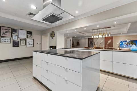 Sleek modern kitchen with a central island, minimalist white cabinetry, and stylish lighting fixtures.