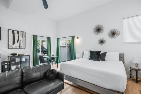 Studio bedroom featuring a comfy king bed, separate dining area, kitchenette, private bath, and outdoor space.