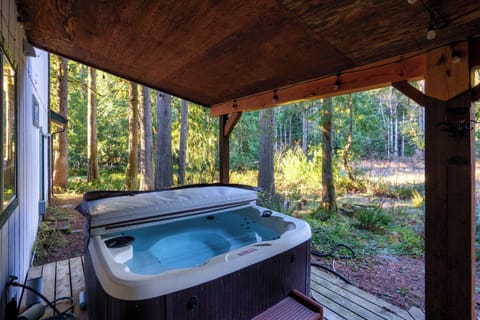The hot tub looks straight into the forest, covered for year-round soaks.