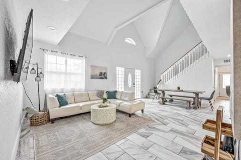 Spacious living area with vaulted ceilings and modern tile flooring.