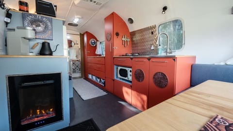 Cozy dining area. There is a large sink, gas stove, microwave and toaster oven.
