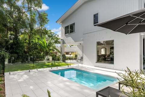 A 4.6 x 2.5-meter plunge pool with two sun lounges and a large umbrella