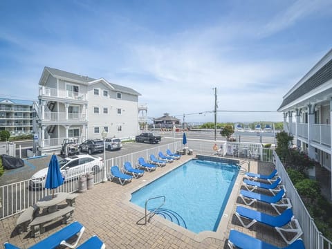 Take a break by the poolside, soaking up the sunshine with a glimpse of the ocean in the distance.