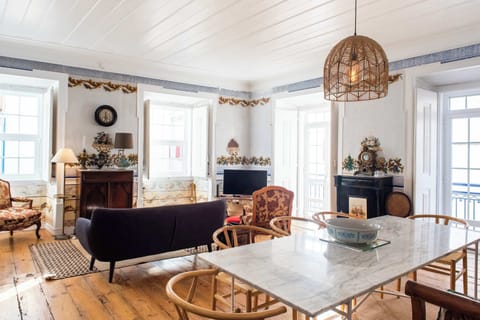 Santo Antonio 1 spacious living area with large windows, showcasing a blend of antique and modern furniture.