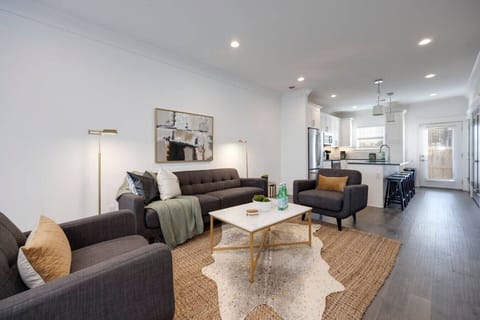 Spacious living room with modern furnishings and a flat-screen TV.