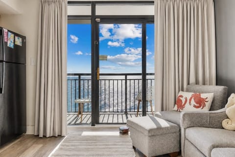 Bright oceanfront balcony with breathtaking views, a spacious spot to relax with large windows framing the sea.