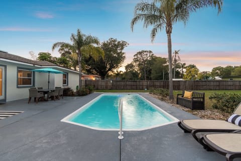Luxury Clearwater heated pool vacation rental with palm trees, sunset views, and spacious deck perfect for large groups and families with children