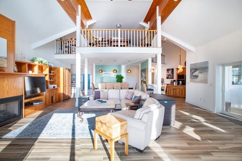 Unwind in a bright open living space with soaring ceilings, cozy seating, and a spacious loft overlooking below