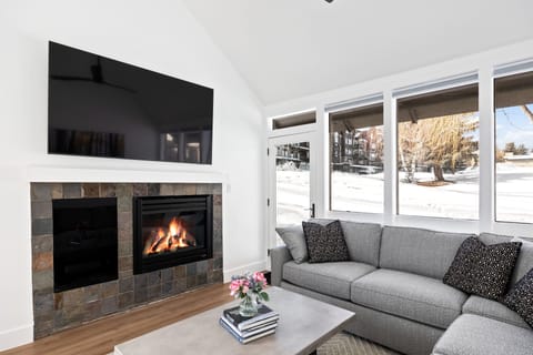 - Cozy living room with fireplace and flat screen TV for relaxing nights  
- Large windows bring in natural light with snowy views outside  
- Comfortable sectional sofa perfect for gatherings and movie nights