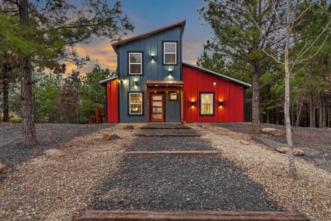 Modern cabin exterior with bold red siding and warm lighting