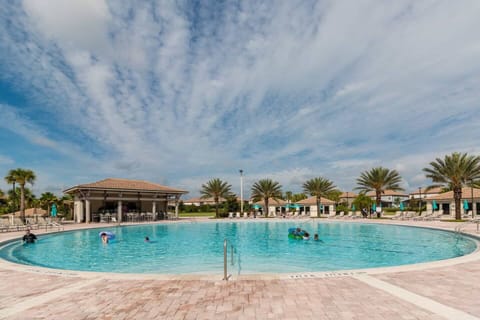 A truly massive pool deck! This wide-angle view shows the scale of the Oasis Club, complete with the elegant clubhouse in the background. Plenty of room to swim laps or play!