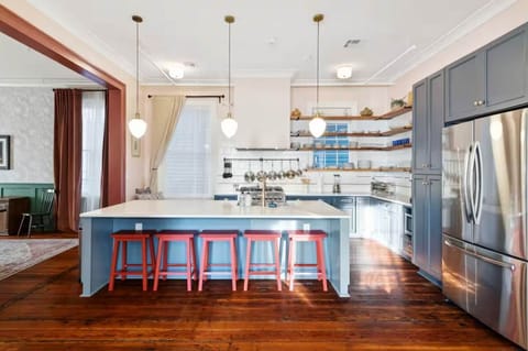 Expansive kitchen featuring a full set of appliances, bar seating at the island counter, and all the cookware, dishes, and utensils you could need.
