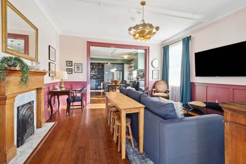 Living room with a comfortable couch, smart TV, and a small workspace with a desk and chair — perfect for relaxing or getting work done.