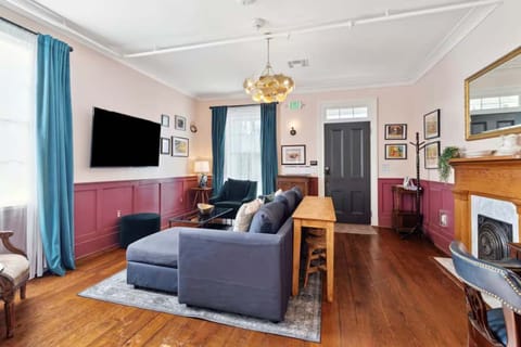 Living room with a comfortable couch, smart TV, and a small workspace with a desk and chair — perfect for relaxing or getting work done.