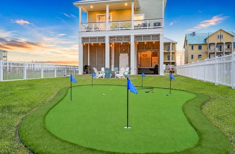 Beachfront luxury vacation home with private putting green, fenced yard, and direct beach views at Ocean Paradise in Galveston, TX near Grand Beach community.
