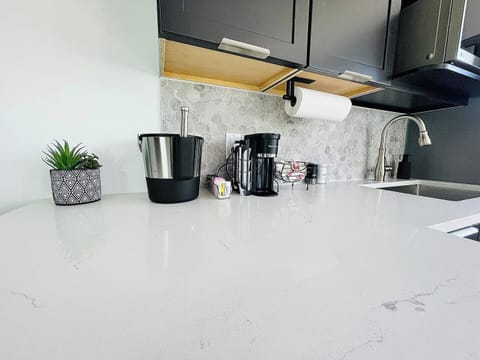 A convenient coffee station equipped with a modern coffee maker, a selection of coffee pods, and essentials like sugar and creamers. This inviting setup ensures guests can enjoy their morning brew effortlessly.