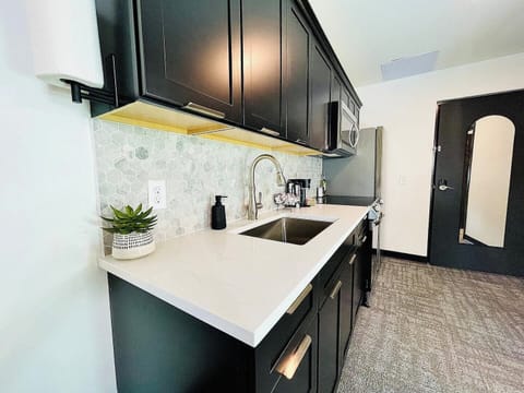stylish kitchen with dark cabinetry, stainless steel appliances, and a well-appointed coffee station for your morning needs.