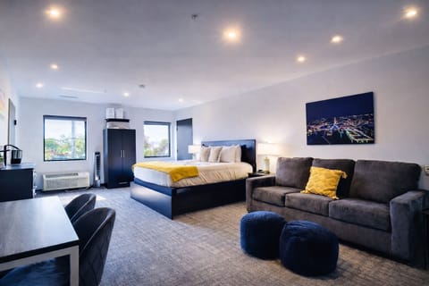 A bright, open room featuring a comfortable bed, work desk, ample storage, perfect for relaxing or working during your stay.