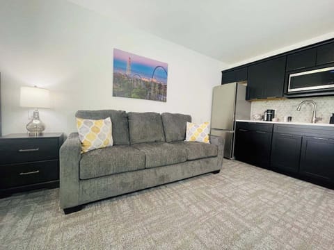 A comfortable sofa with vibrant throw pillows, situated next to a cozy bedroom for added relaxation space.