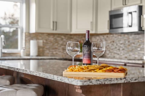 Unwind in style at the kitchen bar, where a welcome wine and glasses await to toast to a perfect getaway. Cheers to relaxation, great company, and unforgettable moments! 🍷✨