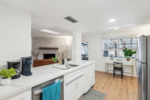 View of the kitchen island from the dining room looking toward the laptop workstation.