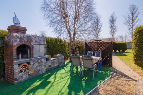 A well-maintained outdoor area featuring a barbecue grill and seating surrounded by greenery.
