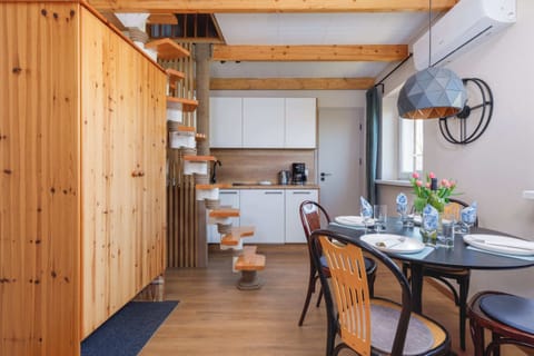 A dining area with wooden furniture and a spiral staircase leading to the upper level.
