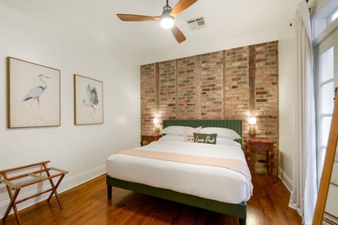Elegant king bedroom with exposed brick walls and luxurious bedding
