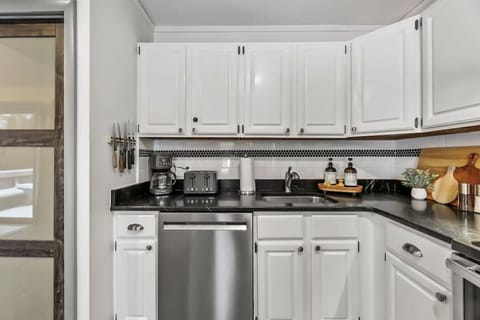 Stylish kitchen with fridge, oven dishwasher, plenty of counter space, and a cozy breakfast bar
