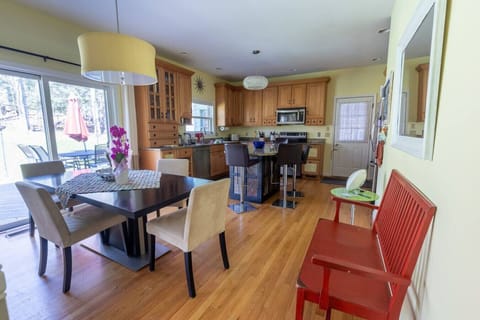 Dining area with seating for four and a bar island with four additional stools.