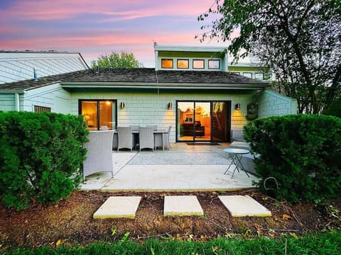 A serene backyard with a spacious patio, outdoor dining, and beautiful greenery, perfect for relaxing evenings.