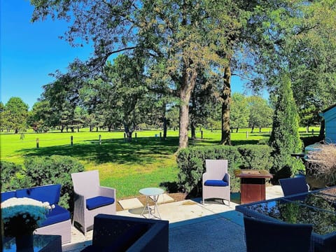 A stunning view of open green spaces of Sawmill Creek Golf Course with comfortable patio seating for cozy gatherings.