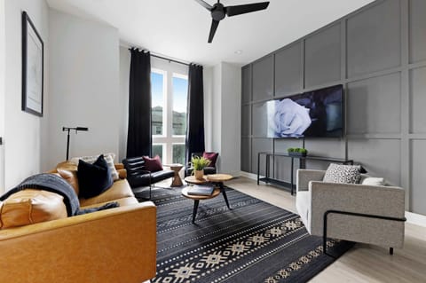 The cozy yet modern living space features a 65-inch, wall-mounted Roku television, perfect for streaming your favorite shows and movies.