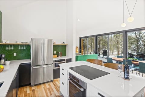 Experience a vibrant, refreshing kitchen where nature meets modern design. This stunning space features a bold green accent wall that brings a sense of calm and rejuvenation to the heart of your home.
