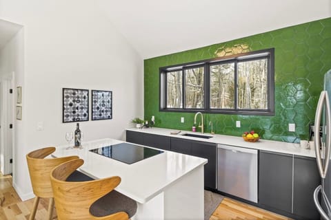 Experience a vibrant, refreshing kitchen where nature meets modern design. This stunning space features a bold green accent wall that brings a sense of calm and rejuvenation to the heart of your home.