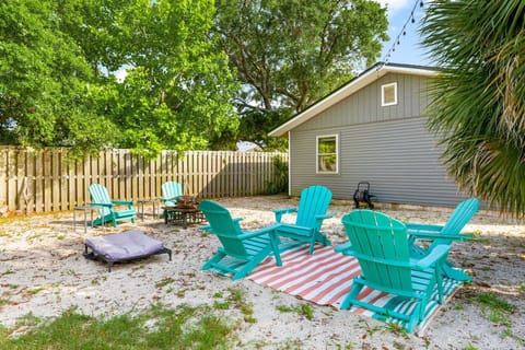 Relax in the spacious backyard with turquoise Adirondack chairs and a fire pit area.