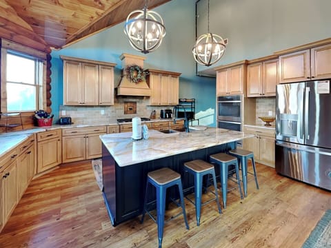 Kitchen with double ovens, double air fryer, island seating for four, dining table for six, ample counter space, and windows showcasing stunning mountain views.