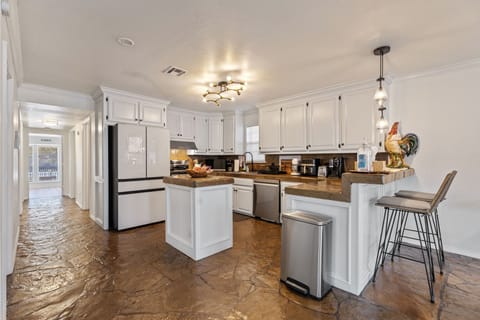 Modern kitchen with center island, bar seating, and pendant lights.
