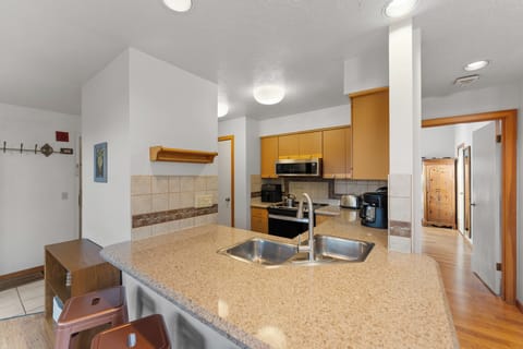 Full kitchen with stainless steel appliances and breakfast bar for casual dining.